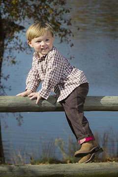 A handsome boy on a fence at Tuscaloosa's Riverwalk. Taken by a Tuscaloosa children's photographer.