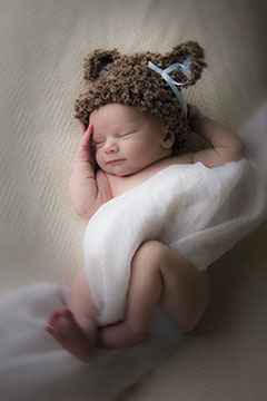 Tuscaloosa, Alabama baby photographer picture of cute baby wrapped in cloth with a hat.
